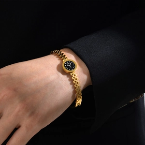 Détail d'une montre dorée avec chiffres romains et cadran noir orné du motif LOVE