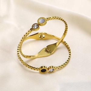 Détails des bracelets dorés avec chiffres romains et zircon sur fond en satin soyeux