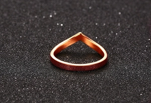 Macro detail of V-shaped rose gold ring featuring a frosted finish and smooth inner band