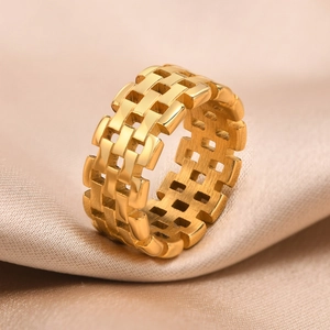 Detail of gold-plated stainless steel watch band ring on luxury champagne silk fabric