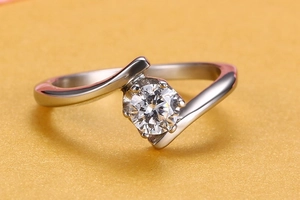 Détail d'une bague argentée à anneau torsadé avec une pierre en zircon et serti à griffes