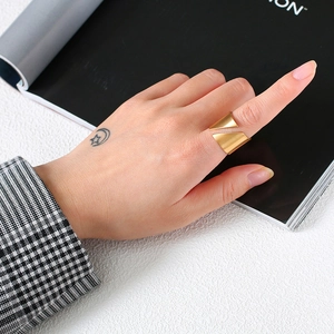 Detailed view of wide gold-plated stainless steel ring with brushed metal texture