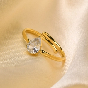 Detail of 18K gold-plated open ring featuring a pear-cut white zircon on champagne silk