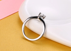 Gros plan d'une bague de fiançailles en argent avec serti à six griffes et zircon brillant