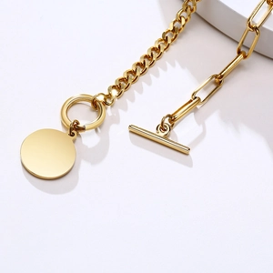 Gros plan du fermoir OT doré 18 carats et du pendentif rond sur bracelet en titane