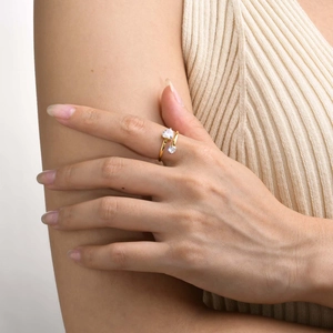 Close-up of golden bypass ring with heart-shaped cubic zirconia on model's finger