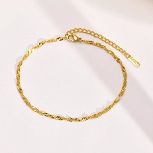 Detailed macro of gold-plated stainless steel twisted wave chain with S.STEEL logo tag