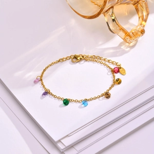 Golden cross chain bracelet featuring seven vibrant multi-colored faceted zircon stones