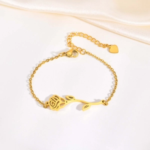 Elegant gold stainless steel rose flower bracelet with heart charm on silk background