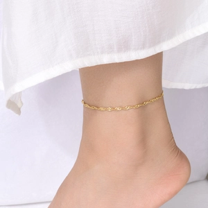 Elegant gold water wave link chain anklet for women on a white dress background