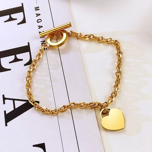 Dettaglio del ciondolo a cuore in oro rosa e chiusura a levetta OT su bracciale in titanio