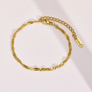 Detailed macro view of gold-plated stainless steel twisted chain bracelet with lobster clasp