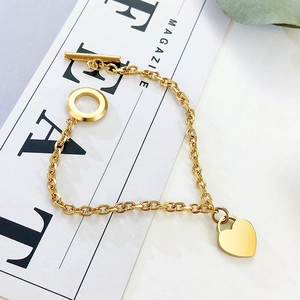 Dettaglio del bracciale a cuore in acciaio al titanio dorato con chiusura OT e maglie