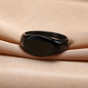 Macro shot of minimalist black polished stainless steel oval signet ring on silk