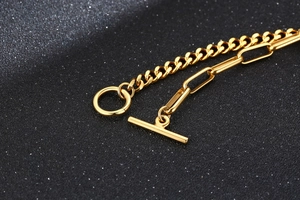 Détail d'un bracelet en acier titane doré 18 carats avec fermoir OT et maillons mixtes