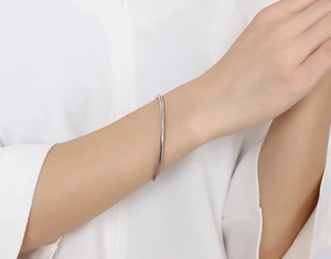 Close-up of minimalist thin silver stainless steel bangle worn on a model wrist