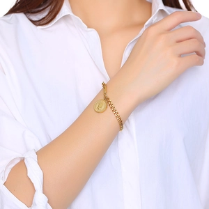 Détail du bracelet en titane plaqué or 18K avec relief Elizabeth sur le poignet d'un modèle