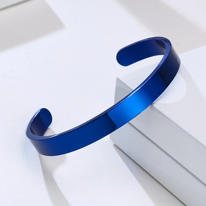 Detail showing the deep blue polished metal surface and open cuff design of the bangle