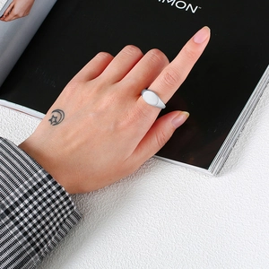 Minimalist silver oval signet ring in polished stainless steel worn by a model