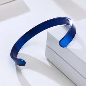 Close-up of polished dark blue stainless steel open bangle with mirror finish