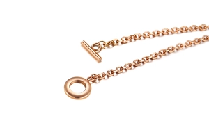 Dettaglio ravvicinato della fibbia OT in oro rosa e della catena su bracciale lucido