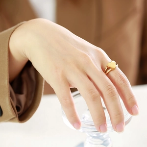 Elegant gold heart cremation ring with double band design worn by a female model