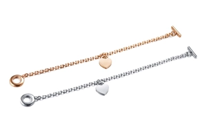 Dettaglio di ciondoli a cuore in oro rosa e argento con bracciali con chiusura a T