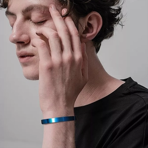 Polished bright blue stainless steel cuff bangle worn on wrist for a minimalist style
