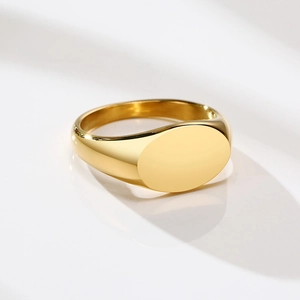 Macro view of polished gold oval signet ring with mirror finish on a clean background