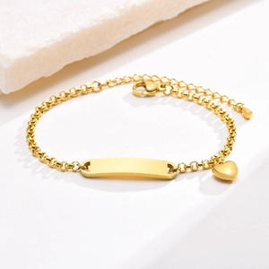 Gold stainless steel ID bracelet with heart charm and engravable bar on white stone