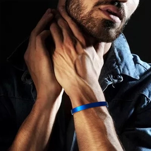 Close-up of a minimalist bright blue stainless steel cuff bangle on a male wrist