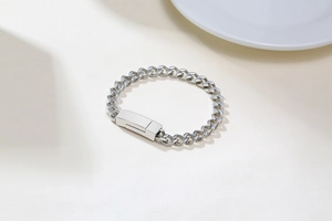 Gros plan d'un bracelet gourmette en acier inoxydable argenté avec fermoir magnétique