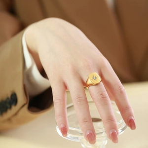 Gold stainless steel signet ring featuring an eight-pointed star and single zircon stone