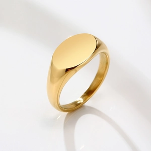 Detailed view of a polished gold signet ring with a smooth oval face and mirror finish