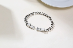 Détail d'un bracelet gourmette en acier inoxydable argenté avec fermoir magnétique rectangulaire