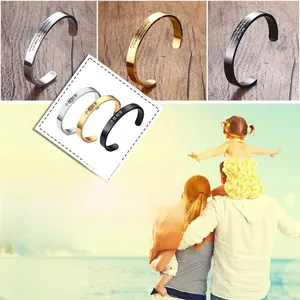 Detailed view of three polished stainless steel bangles with personalized engraving text