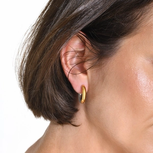 Two-tone gold and silver thick hoop earring with polished finish on model's ear