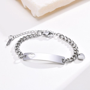 Detail view of silver heart bracelet showing the curved plate and lobster clasp