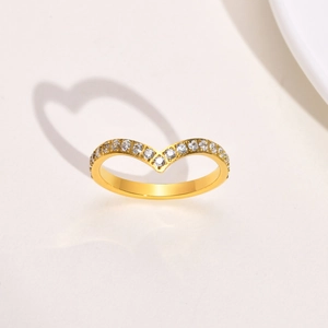 Macro view of gold V-shaped zircon ring with heart-shaped shadow on white background