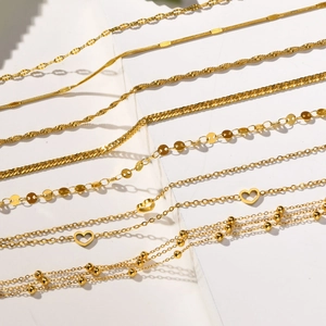 Detail view of multiple layered 18K gold-plated stainless steel chains and heart pendants