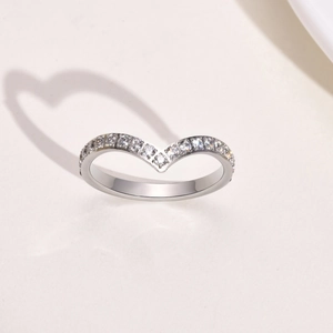 Macro shot of V-shaped gold ring casting a romantic heart-shaped shadow on white background
