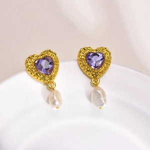 Vue détaillée des boucles d'oreilles cœur vintage dorées avec zircon violet et perles