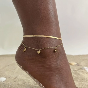 Double-layer gold stainless steel anklet with moon, heart and star charms on sandy beach