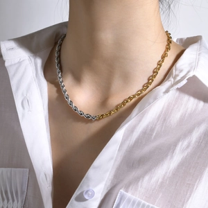 Primo piano di una collana asimmetrica bicolore in acciaio inossidabile su modella