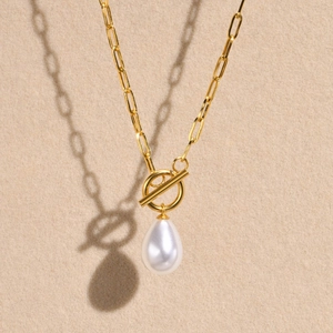 Détail macro du collier chaîne trombone doré avec perle en poire et fermoir à bascule OT