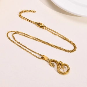 Collana con ciondolo a serpente in acciaio dorato con squame e catena incrociata