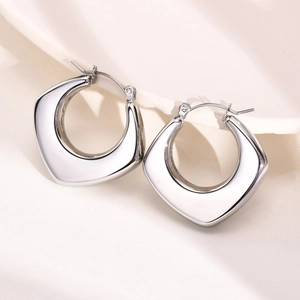 Detailed view of chunky silver geometric hoop earrings with polished mirror finish
