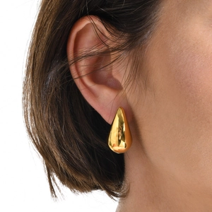 Close-up of gold hollow teardrop earrings with high-polish mirror finish on a model