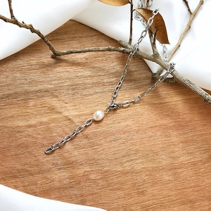 Detailed view of silver tone textured link chain with a baroque freshwater pearl pendant