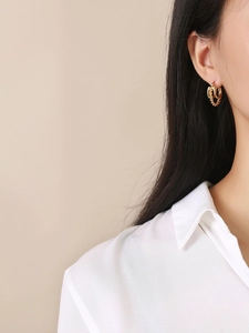 Boucles d'oreilles créoles triple rang en acier doré avec motif torsadé sur mannequin
